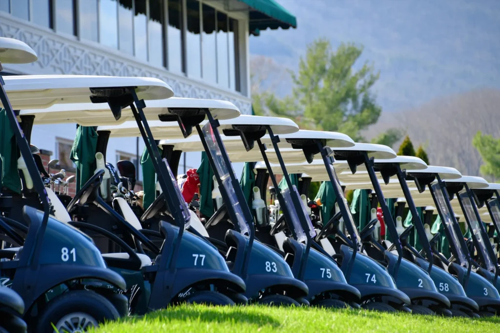 A row of golf carts parked in a line